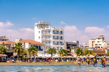 Larnaca, Kıbrıs - 27 Ağustos 2016: Finikoudes Beach Otel ve güneşlenenbirileri varsa.