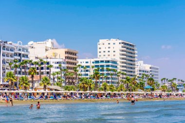 Larnaca, Kıbrıs - 27 Ağustos 2016: Finikoudes Beach ile çok sayıda otel ve arka planda kafe.