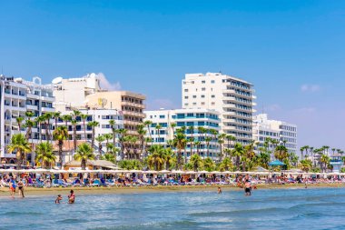 LARNACA, CYPRUS - AUGUST 27, 2016: Finikoudes Beach with the numerous hotels and cafes on the background. clipart