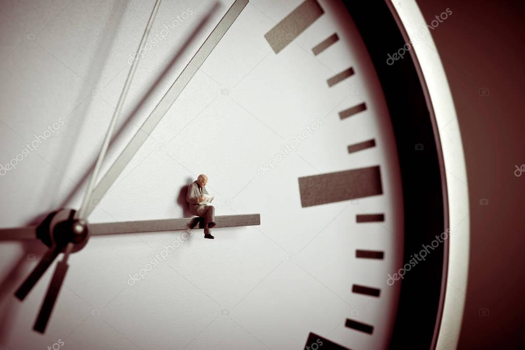 Businessman sitting on giant clock