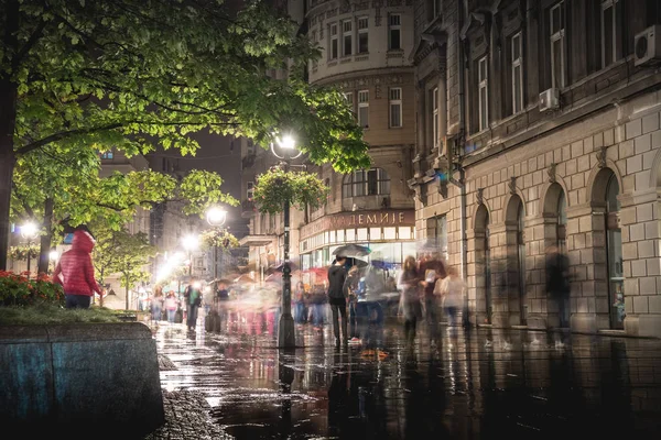 BELGRADE, SERBIA - 25 de septiembre: Rainy inght en la calle Knez Mihailova el 25 de septiembre de 2015 en Belgrado, Serbia. Calle es la principal milla de compras de Belgrado . — Foto de Stock