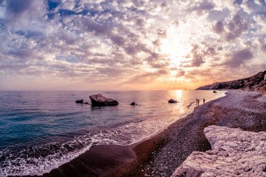 Siluetleri Petra tou Romiou yakınındaki gün batımında. Baf bölgesi, Kıbrıs