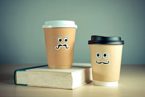 Dos tazas de café para llevar lindo y libro — Foto de Stock