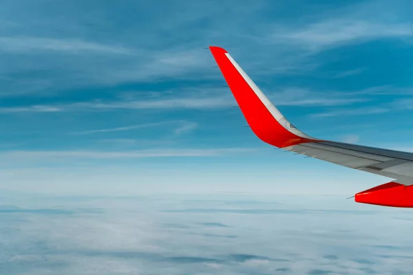 Vleugel van een vliegtuig vliegen boven de witte wolken — Stockfoto