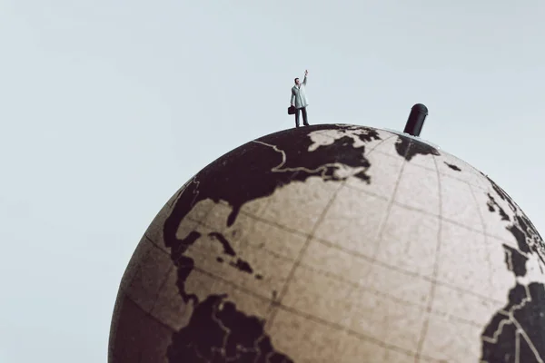 Businessman rise hand up to call for something while standing on Earth globe — Stock Photo, Image