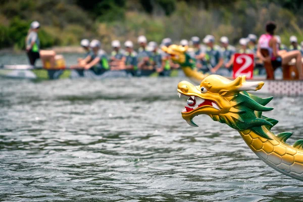 Dragon\'s head with dragon boat racing team at the back