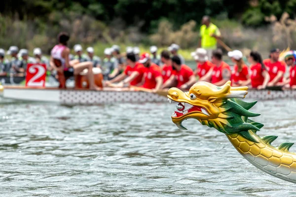 Dragon boat\'s head with racing team on the background