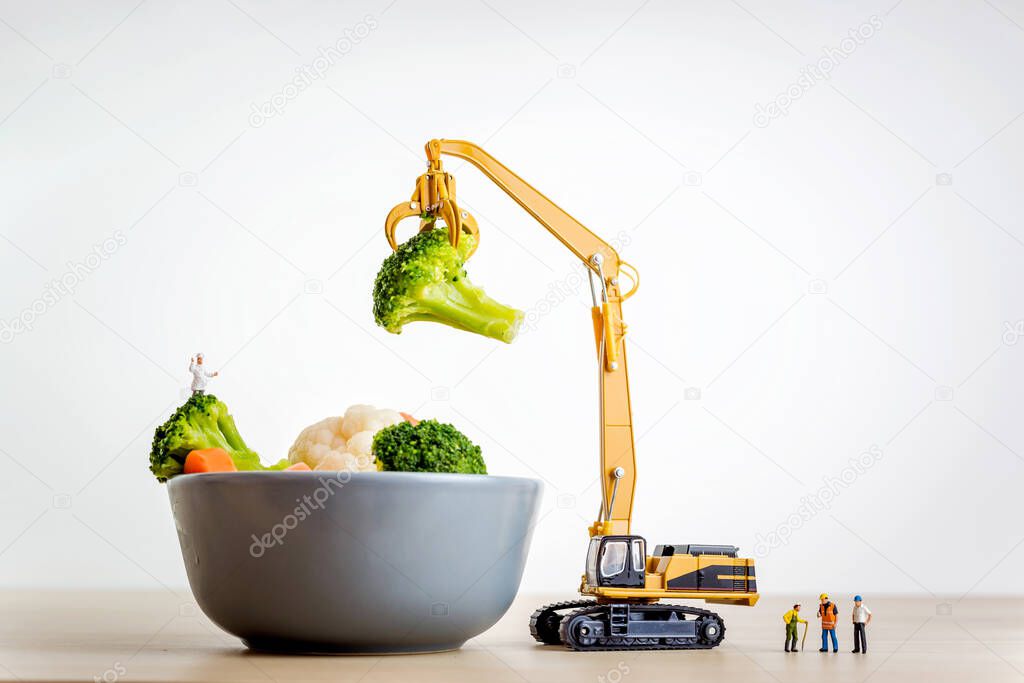 Miniature people making salad. Cooking concept