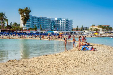 AYIA NAPA, CYPRUS - 21 Nisan 2018: Nissi plajında dinlenen turist kalabalığı