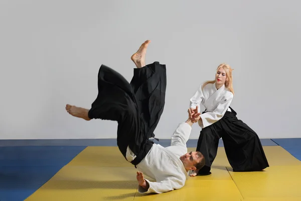 Aikido dövüş sanatı. kız ve erkek teknikleri göstermek — Stok fotoğraf