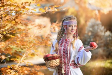 Girl in Russian folk costume holding apples  clipart