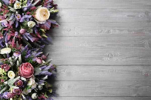 Floral arrangement on wooden texture background. — Stock Photo, Image