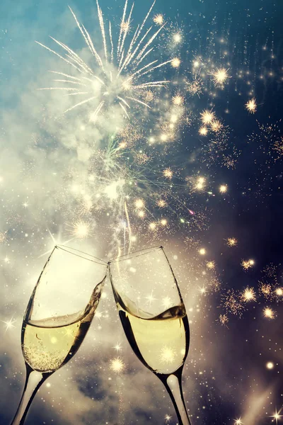 Glasses with champagne against fireworks — Stock Photo, Image