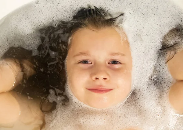 Portrait of a happy little girl in the foam. — Stock Photo, Image