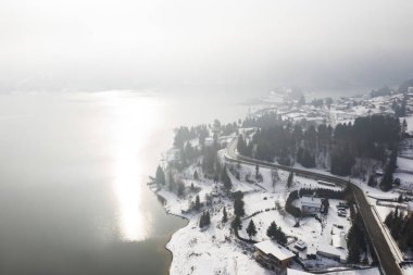 Romanya 'nın Colibita Gölü üzerinde kışın sihirli sisli gün doğumu.