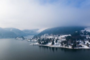 Romanya 'nın Colibita Gölü üzerinde kışın sihirli sisli gün doğumu.