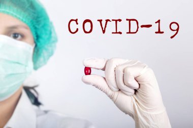 COVID-19 - Coronavirus hastalığı - 2019-nCoV, WUHAN Corona virüsü. Doktor elinde ilaç tutuyor. Yazıt Coronovirus COVID-19