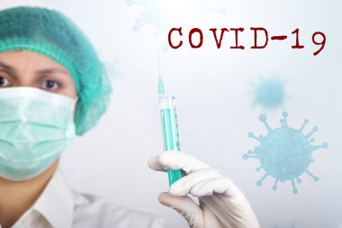 COVID-19 - Coronavirus hastalığı - 2019-nCoV, WUHAN Corona virüsü. Şırıngalı doktor iğneye hazırlanıyor..