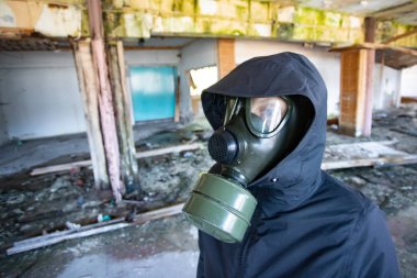 Yıkılmış bir binada gaz maskeli kıyamet sonrası hayatta kalanlar. Çevre felaketi, mahşer kavramı.