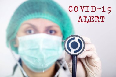 COVID-19 - Coronavirus hastalığı - 2019-nCoV, WUHAN Corona virüsü. Stetoskop tutan doktor. Yazıt Coronovirüs COVID-19
