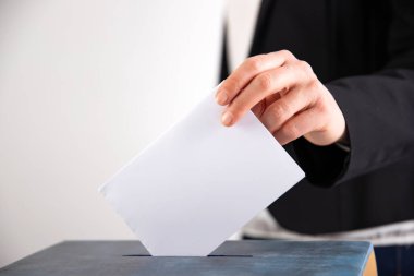 Oy sandığına oy veren bir seçmenin eli. Seçim kavramı.