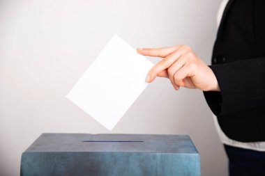 Oy sandığına oy veren bir seçmenin eli. Seçim kavramı.