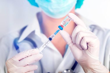 COVID-19 - Coronavirus hastalığı - 2019-nCoV, WUHAN Corona virüsü. Şırıngalı doktor iğneye hazırlanıyor..