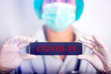 COVID-19 - Coronavirus hastalığı - 2019-nCoV, WUHAN Corona virüsü. Coronovirus COVID-19 yazısını tutan doktor.