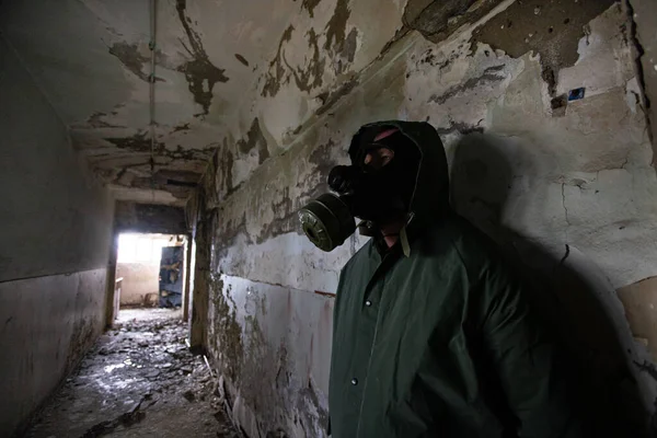 Post apocalyptic survivor in gas mask in a ruined building. Environmental disaster, armageddon concept.