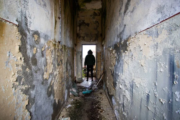  Yıkılmış bir binada gaz maskeli kıyamet sonrası hayatta kalanlar. Çevre felaketi, mahşer kavramı.