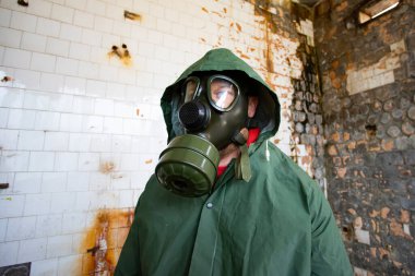  Yıkılmış bir binada gaz maskeli kıyamet sonrası hayatta kalanlar. Çevre felaketi, mahşer kavramı.