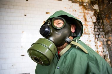  Yıkılmış bir binada gaz maskeli kıyamet sonrası hayatta kalanlar. Çevre felaketi, mahşer kavramı.