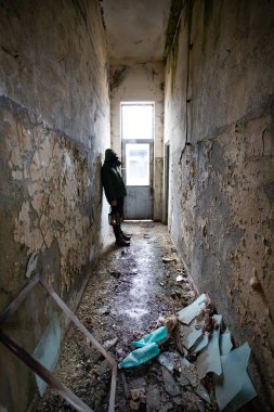  Yıkılmış bir binada gaz maskeli kıyamet sonrası hayatta kalanlar. Çevre felaketi, mahşer kavramı.