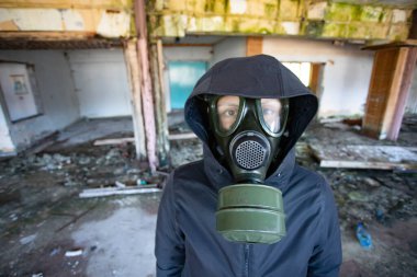 Yıkılmış bir binada gaz maskeli kıyamet sonrası hayatta kalanlar. Çevre felaketi, mahşer kavramı.