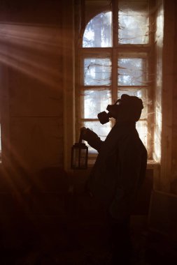 Yıkılmış bir binada gaz maskeli kıyamet sonrası hayatta kalanlar. Çevresel afet kavramından sonraki umut.