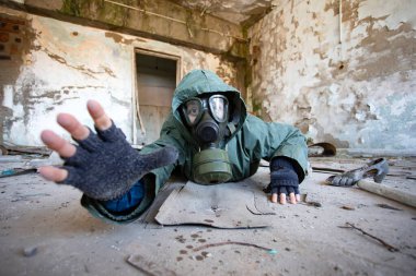 Gaz maskeli kıyametten kurtulan biri yıkılmış bir binada yardım istiyor. Çevre felaketi, mahşer kavramı.