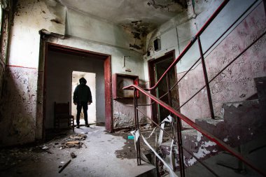  Yıkılmış bir binada gaz maskeli kıyamet sonrası hayatta kalanlar. Çevre felaketi, mahşer kavramı.