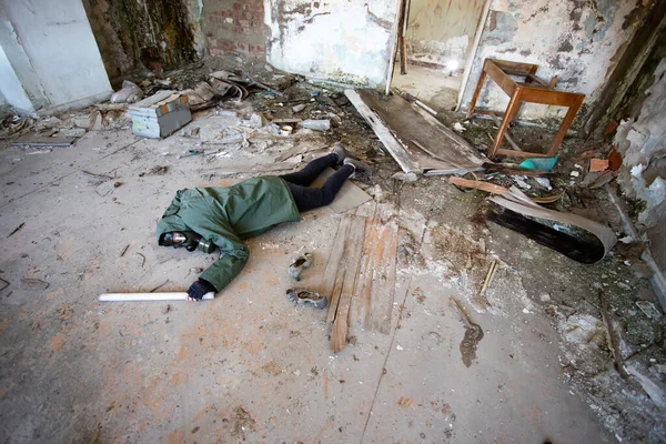 破壊された建物の地面に落ちたガスマスクの黙示録的な生存者を投稿します 環境災害 アーマゲドンの概念 — ストック写真
