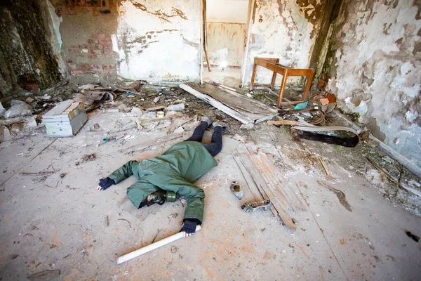 破壊された建物の地面に落ちたガスマスクの黙示録的な生存者を投稿します 環境災害 アーマゲドンの概念 — ストック写真