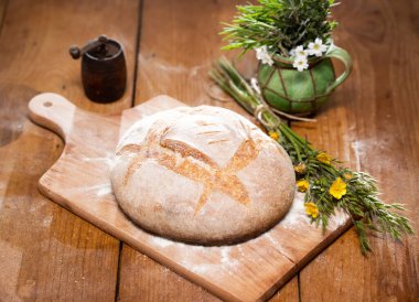 Tahta kesme tahtasında taze pişmiş buğday ekmeği. Ev yapımı köy ekmeğiyle sakin bir hayat.