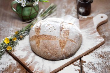 Tahta kesme tahtasında taze pişmiş buğday ekmeği. Ev yapımı köy ekmeğiyle sakin bir hayat.