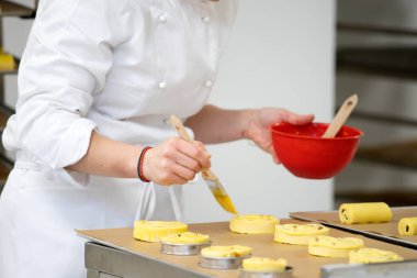 Fırında çalışan fırıncı geleneksel Fransız ekmeği ve pastası yapıyor..