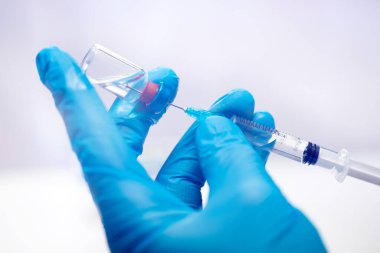 Bilim adamları ellerinde koronavirüs, covid-19 aşısı hastalığı olan mavi eldivenlerle klinik aşı aşısı için hazırlanıyorlar. İlaç ve uyuşturucu kavramı