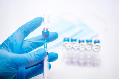 Bilim adamları ellerinde koronavirüs, covid-19 aşısı hastalığı olan mavi eldivenlerle klinik aşı aşısı için hazırlanıyorlar. İlaç ve uyuşturucu kavramı