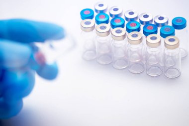 Bilim adamları ellerinde koronavirüs, covid-19 aşısı hastalığı olan mavi eldivenlerle klinik aşı aşısı için hazırlanıyorlar. İlaç ve uyuşturucu kavramı