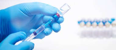 Bilim adamları ellerinde koronavirüs, covid-19 aşısı hastalığı olan mavi eldivenlerle klinik aşı aşısı için hazırlanıyorlar. İlaç ve uyuşturucu kavramı