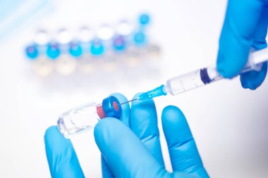Bilim adamları ellerinde koronavirüs, covid-19 aşısı hastalığı olan mavi eldivenlerle klinik aşı aşısı için hazırlanıyorlar. İlaç ve uyuşturucu kavramı