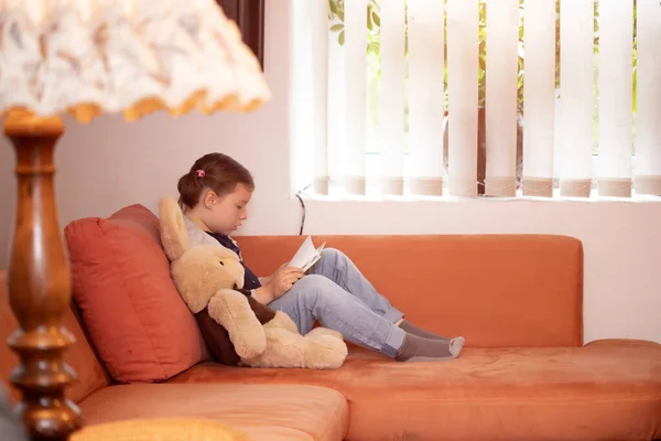 Маленька Дівчинка Читає Історію Своїх Плюшевих Ведмедів Лежачи Ліжку — стокове фото