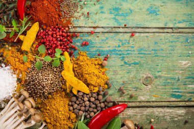 Ahşap masada çeşitli renkli baharatlar var.