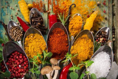Ahşap masada çeşitli renkli baharatlar var.